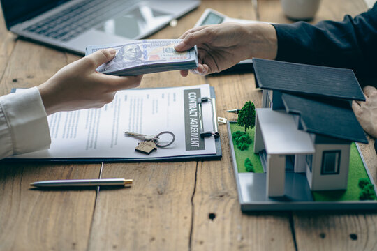 Home agents talk to new home buyers and offer good interest rates and calculate clients on mortgage financing to help make real estate concept decisions.