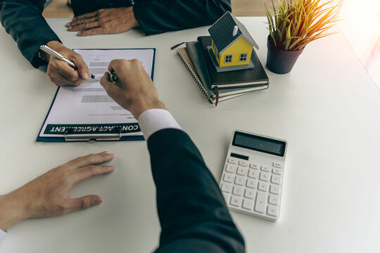 Home agents talk to new home buyers and offer good interest rates and calculate clients on mortgage financing to help make real estate concept decisions.