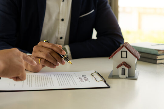 Home agents talk to new home buyers and offer good interest rates and calculate clients on mortgage financing to help make real estate concept decisions.