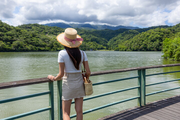 Fototapeta premium Travel woman look at the water pond