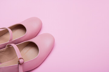 women's pink shoes with a clasp on a pink background with copy space