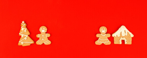 Happy New Year's 2023 set of gingerbread man in face mask from ginger biscuits glazed sugar icing decoration on classic traditional red background, minimal seasonal pandemic winter holiday banner
