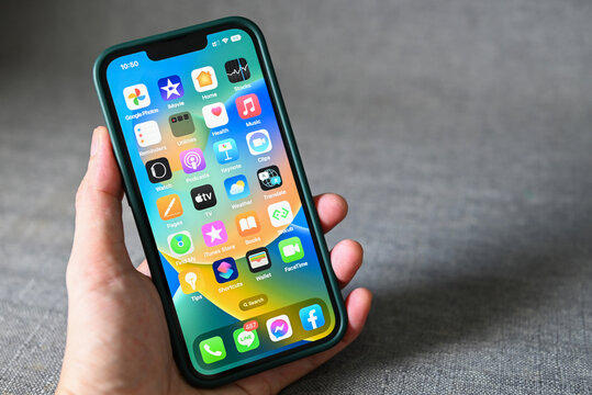 iPhone with iOS 16 logo on home screen, close up new operating system 2022-2023 on iPhone apple devices sub version ios 16 screen display man hand holding iPhone : Bangkok, Thailand - September 2022