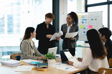 Group of diverse colleagues discussing for financial report with presentation on flipchart during a small conference in the office