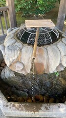 Hand washing fountain at the Japanese shrine, in shapes of the lotus flower, beautiful remains of...