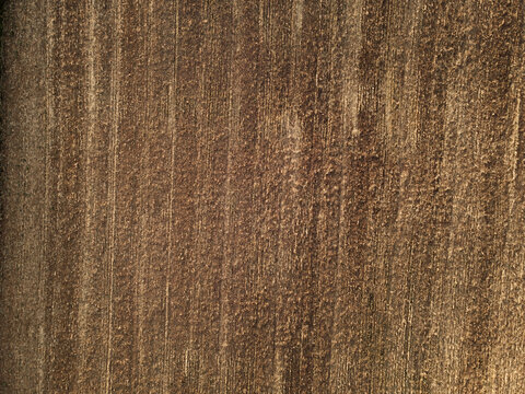 Agriculture concept. Aerial drone view of brown dirt rural agricultural field background in high altitude. Harvested crops with visible stubble. Earth view from above. Image contain noise and blur