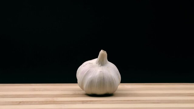Head of garlic enters, stops and exits the scene. Stop motion animation.