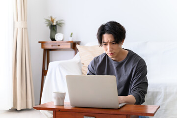 パソコンをするハンサムな男性 　悩む