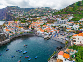 Fototapeta na wymiar Madeira. Camara de Lobos Aerial View. Small fisherman village with many small boats in a bay. Madeira Island, Portugal.