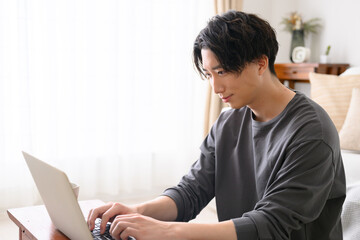 Obraz na płótnie Canvas : パソコンをするハンサムな男性　逆光　横顔