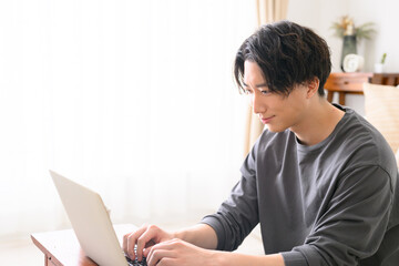Handsome man at computer, backlit, profile