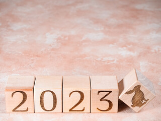 Text 2023 and the rabbit symbol on wooden cubes as concept of motivation to new achievements