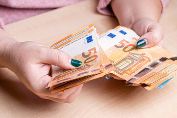 business, finance, saving, banking and people concept - close-up of woman hands counting euro money