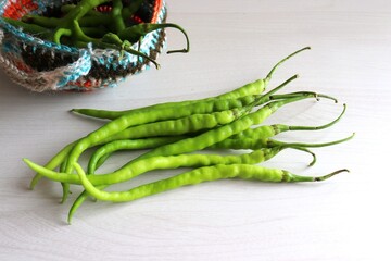 Farm fresh organic Green chili peppers. Freshly harvested healthy and spicy chilies in a basket on...