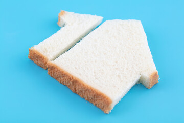 Cut slices of bread in the shape of a house on a blue background