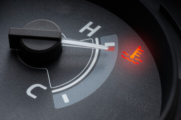 Pointer at the high temp point of the temperature gauge in the vehicle radiator and the symbol has...