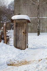 Wooden outhouse toilet on wintertime. Front view