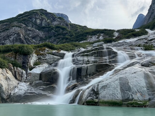 Obraz na płótnie Canvas Waterfalls come down the fjord walls in Endicott Arm, South East Alaska