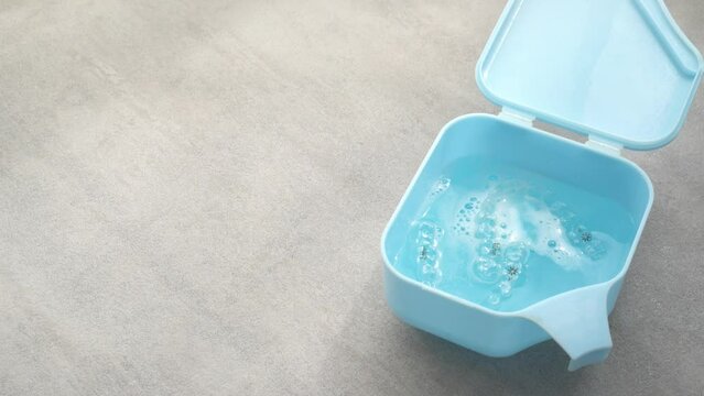 Cleaning orthodontic clear aligners for teeth with a tablet cleaner.