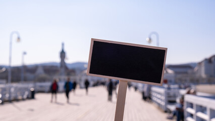 Blanco zwart reclamebord tegen menigten toeristen De Sopot Pier in de stad aan de Baltische Zee. Lege mockup-sjabloon Bezoekers lopen De pier is de langste houten pier van Europa. Schoolbordlabel