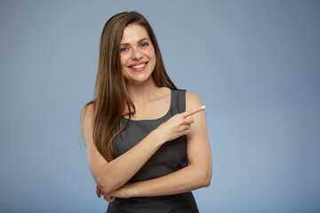 Obraz premium Smiling business woman pointing with finger side away at copy space. isolated portrait.