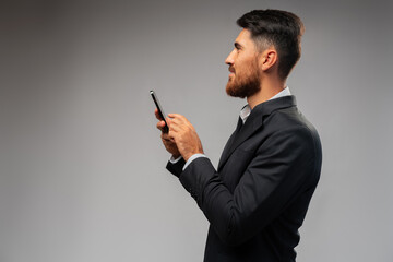 Young businessman using mobile phone in studio