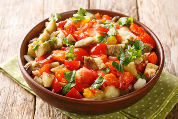 Grilled eggplant salad with baked peppers, onions, tomatoes and garlic close-up in a bowl on the table. Horizontal