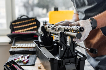 The gunsmith maintaining his rifle in a workshop