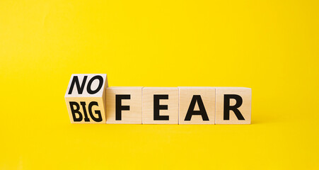 No fear vs big fear symbol. Turned wooden cubes withs words Big fear and No Fear. Beautiful yellow background. Business concept. Copy space.