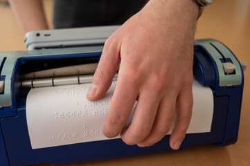 Blind man using braille typewriter. 