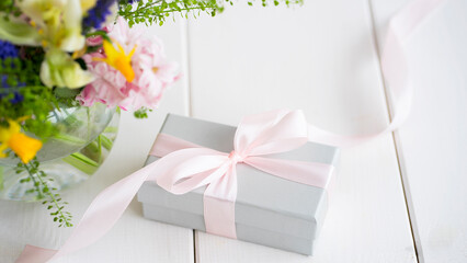 Box with a gift and a bouquet of flowers. Image with selective focus