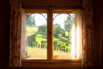 Front view of wooden window with curtains, sunny landscape rural view with trees and hill. Rustic holiday, digital detox