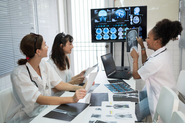 Team of medical doctor meeting in the brain research laboratory by monitor showing MRI, CT scans...