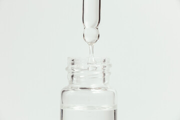 Pipette with a glass bottle on a light background.