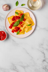 Delicious appetizing ravioli with tomato sauce and basil