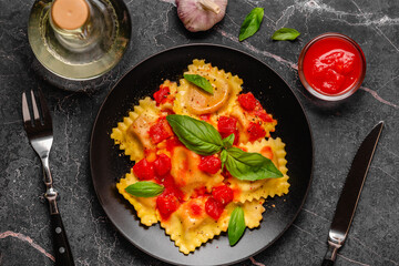Delicious appetizing ravioli with tomato sauce and basil