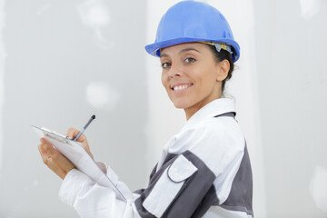 happy woman builder holding clipboard