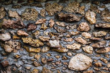 Old style wall made of rough stones with cement. Ancient grunge stones wall backdrop. Background of old vintage wall.Ancient style stone fence decoration to be beautiful and strong with natural stone.