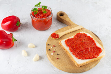 Toast with ajvar vegetable paste on a wooden board.