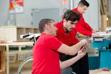 worker instructing his handicapped apprentice