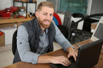 male worker using laptop in his workshop