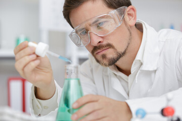 researcher at work in a laboratory with a blood pipette - obrazy, fototapety, plakaty