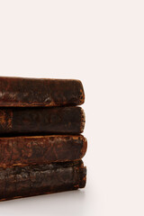 Stack of old worn shabby Jewish books in leather binding on white background with reflection. Closeup. Selective focus.
