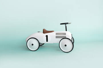 Retro style beige toy car on blue background. Stylish toy for toddler boy. Kid's playing room interior. Copyspace