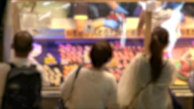 ぼかし背景素材: 市場で屋台の握り寿司をテイクアウト用に選ぶ人々の後ろ姿  4K 2022年9月 山口県 唐戸市場