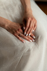 Bride's hands on wedding dress