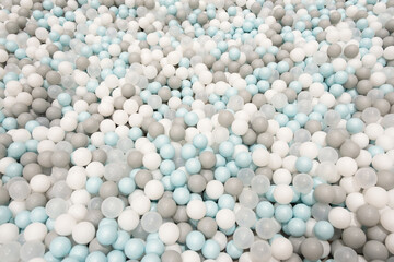Colorful white, grey, blue plastic balls background for baby activity. Kid's playing room interior. Copyspace