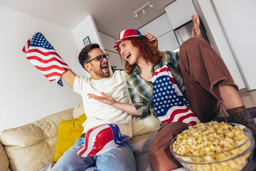 Cute couple looking excited and happy after their favorite football team scored a touchdown