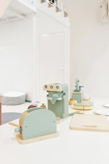 Pastel colorful toy kitchen with wooden kitchen utensils ready for children play. Stylish kid's playing room interior for toddlers