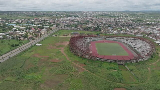 AERIAL - Abandoned stadium building in Jos Plateau, Nigeria, rising tilt down